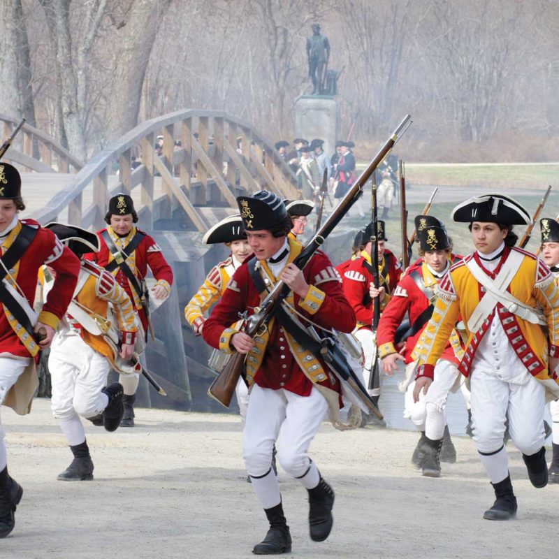 soldiers running in the park with rifles in uniform for Patriots Day